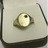 A hallmarked 9ct gold gents signet ring with engraved and star detail to top.