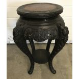 A oriental wooden plant stand with carved flower detail to body and legs.