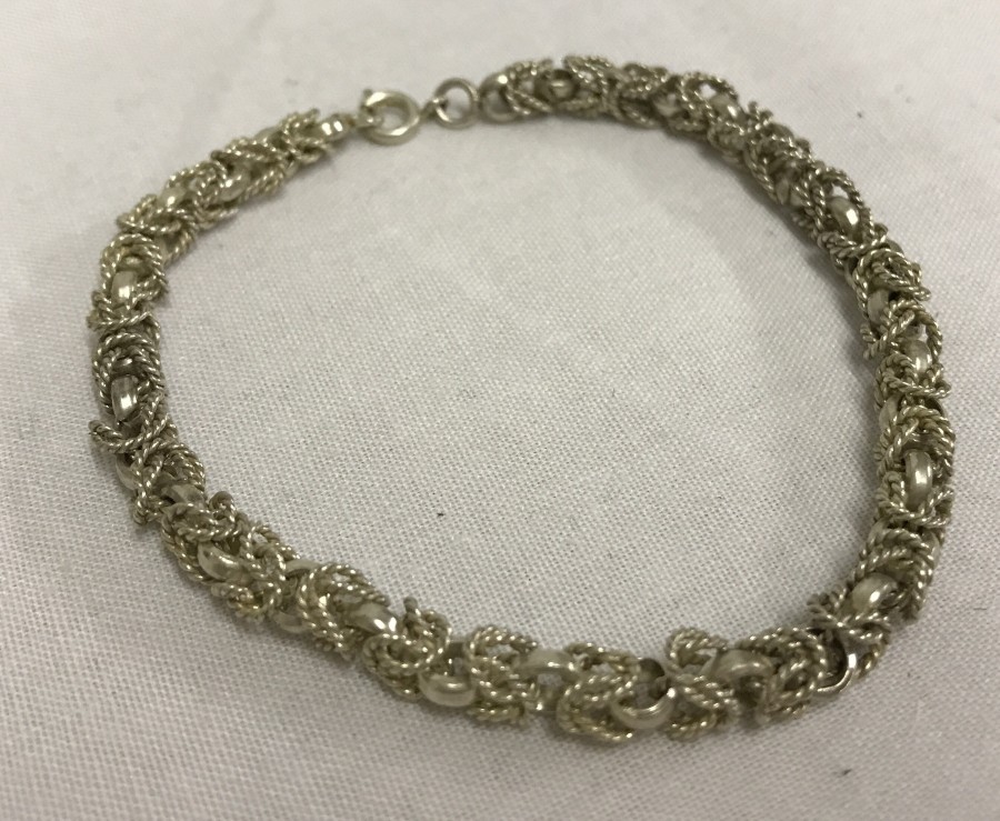 An attractive un-hallmarked white metal chain & rope link bracelet.