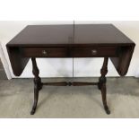 A reproduction mahogany drop leaf table.