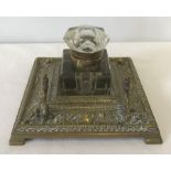 A brass desk / penstand decorated with art nouveau style floral detail with central glass ink bottle