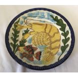 A hand painted terracotta plate depicting a lobster and a fish by Anibal Rosado.