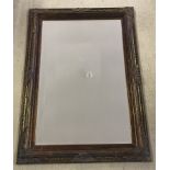 A mirror with bronze coloured frame.