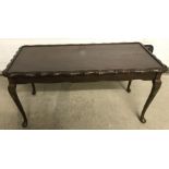 A reproduction coffee table with cabriole legs and piecrust edge to top.