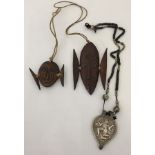 2 small vintage carved horn tribal head masks. Together with a white metal Indian god pendant.