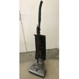 A Vintage upright vacuum cleaner by Hoover.