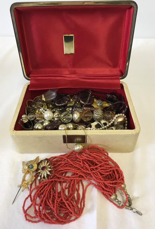 A vintage cream jewellery box and contents.