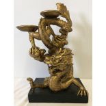A gilt resin dragon candle / incense holder mounted on a black base.