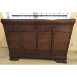 A dark wood 2 door, 2 drawer sideboard with carved detail to handles.