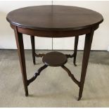 An Edwardian circular occasional table with brass castors and tapered legs.