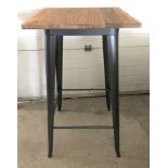 A modern bar style table with pressed steel frame and solid elm wooden top.