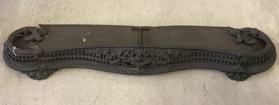 A large decorative wrought iron fire fender.