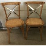 A pair of modern natural oak dining chairs.