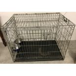 A large dog crate with internal feed/water bowls.
