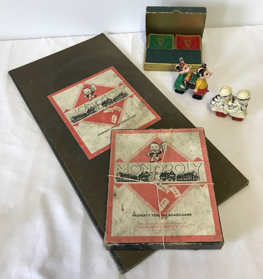 A quantity of vintage toys comprising Monopoly board game, Guinness playing cards and wind up toys.