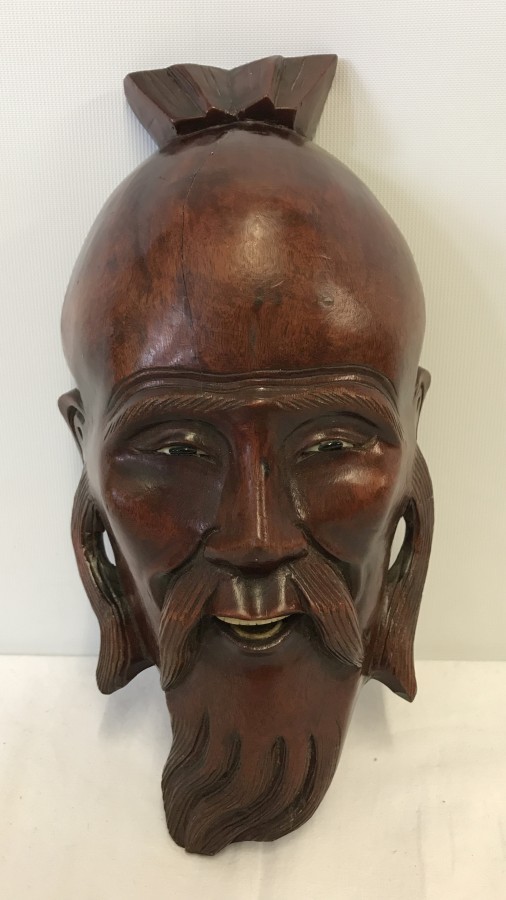 A Thai wooden wall hanging face mask.