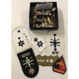 A box of military buttons, badges, insignia patches and misc items.