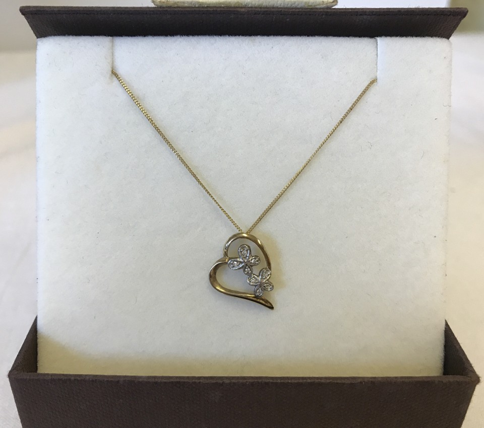 A 9ct gold floating heart pendant with diamond set butterfly detail on 9ct gold chain.