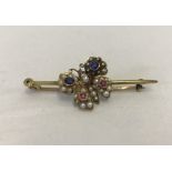A butterfly bar brooch set with sapphires, rubies, seed pearls and diamond.