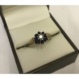 A 9ct gold cluster ring set with 8 small sapphires and central diamond.