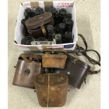 A box of binoculars, opera glasses and cases in varying conditions.