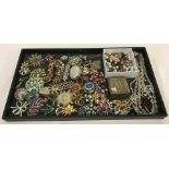 A tray of 40+ vintage costume brooches, many with stones missing.
