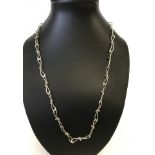 A decorative silver chain necklace with unusual twisted links.
