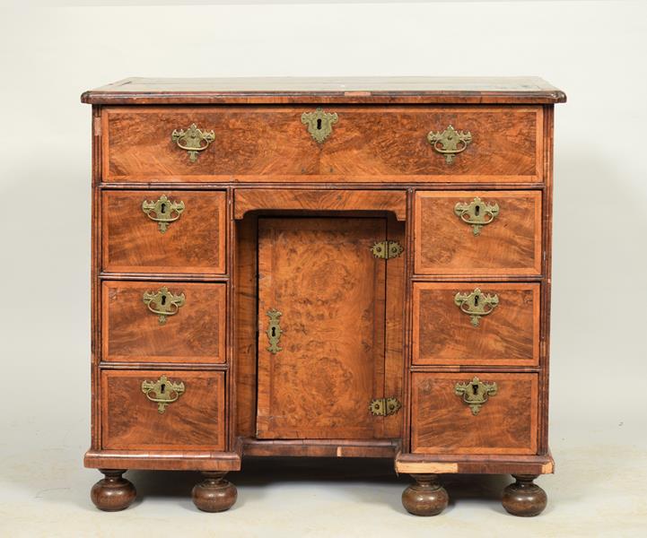 An 18c figured walnut veneered kneehole desk of rectangular form, the upper section with moulded