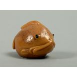 A Japanese Meiji period carved nut in the form of a puffa fish, base signed, 1.5w.