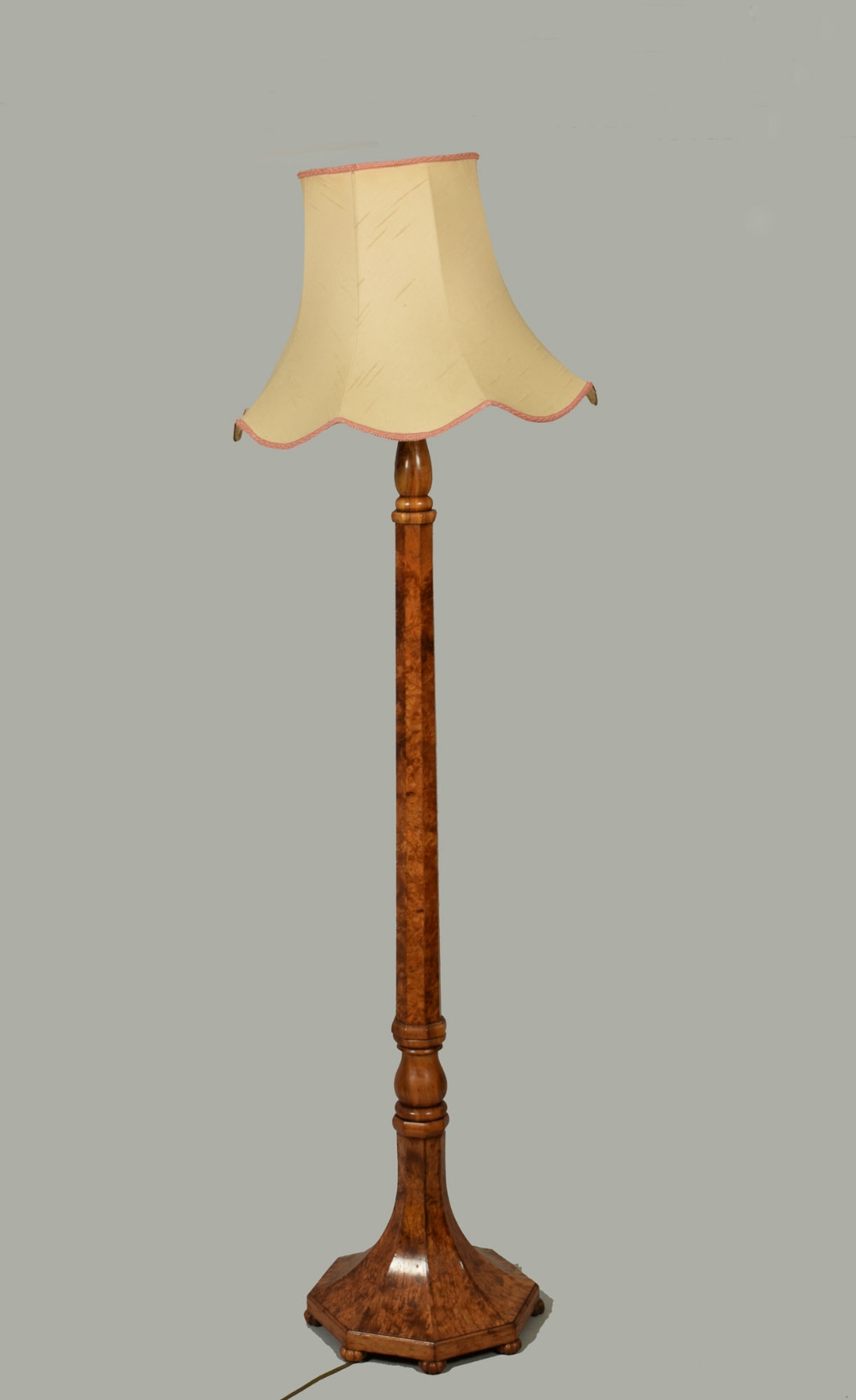 A burr wood veneered standing lamp with facet carved baluster column, supported on an octagonal