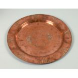 An Art Nouveau copper wall plaque of circular dished form, embossed and chased with the stylistic