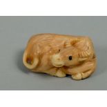 A Japanese Meiji period carved ivory netsuke in the form of a recumbent buffalo, base signed, 1.