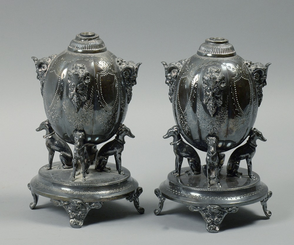 A pair of Elkington & Co Brittania metal oil lamp fonts each with rams head grotesque masks on lobed