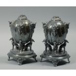 A pair of Elkington & Co Brittania metal oil lamp fonts each with rams head grotesque masks on lobed
