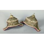 Two 19c Afghan tribal head dresses with cowie and stamped metal plate decoration, plume sockets