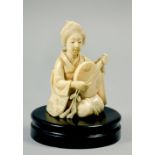 A Japanese Meiji period carved ivory figure of a Japanese lady robed and kneeling playing an