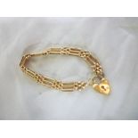 A 9ct gold gate link bracelet with padlo