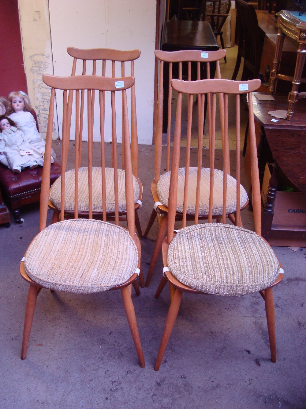 A set of four Ercol beechwood stickback kitchen chairs with solid elm seats together with a