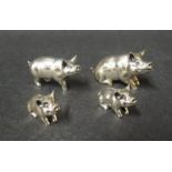 A set of four Mark Haughton silver miniature pig family figures,