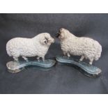 A pair of painted cast iron sheep door stops