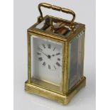 A brass cased carriage clock, bevel glass case, Roman numerated chapter ring,