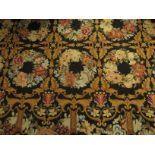 A large Oriental needlework rug, all over decoration of floral wreaths,