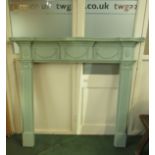 A green painted Regency style pine fire surround decorated with ribbons and swags