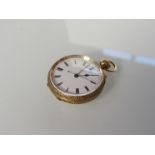 A gold lady's fob watch with engraved case,