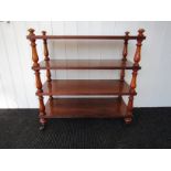 A 19th Century pitch pine four tier shelving unit with fruitwood turned supports to brass and brown