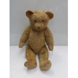 An early 20th Century straw filled teddy bear with glass eyes