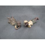 A pair of cold painted bronze figures of recumbent children