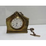 An Ingersoll base metal pocket watch hung on brass frame