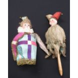 Two bulbous shaped bisque headed musical girl dolls dressed as Jesters a/f