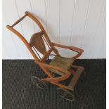 A folding four wheel dolls chair with image of Dutch boy and girl to back